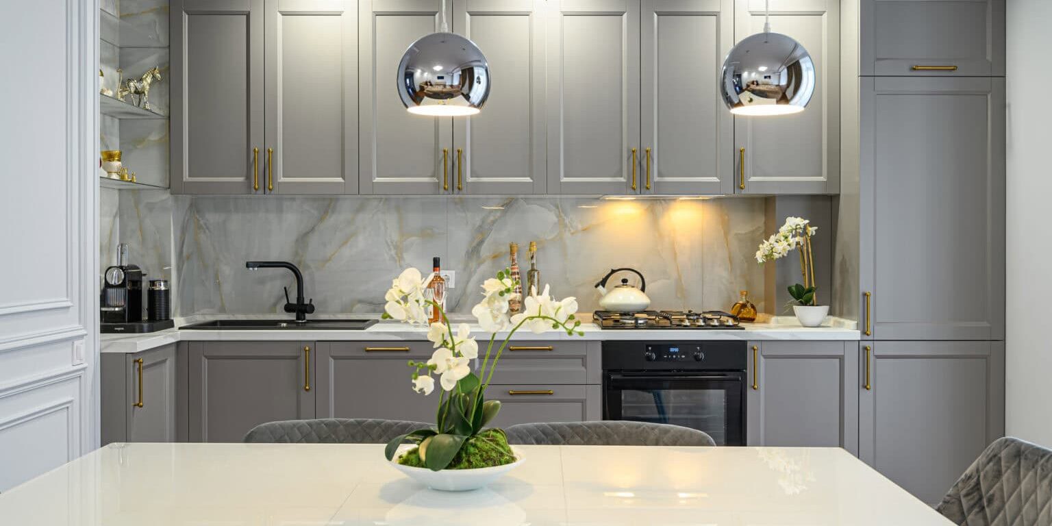 Grey and white contemporary classic kitchen interior with dining table designed in modern style, front view