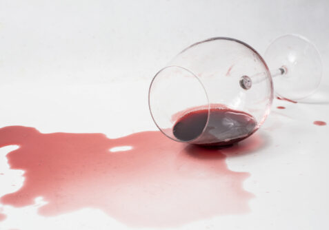 Spilled,Red,Wine,Out,Of,Glass,On,White,Surface